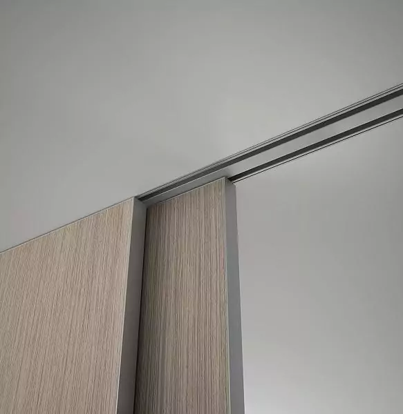 STRATUS–FILO, Alu, Velino model, natural veneer Rovere Canuto, end edge in Chrome Matt finish. Sliding double–leaf partition in the opening, hidden track in the ceiling. A fragment of canvases.